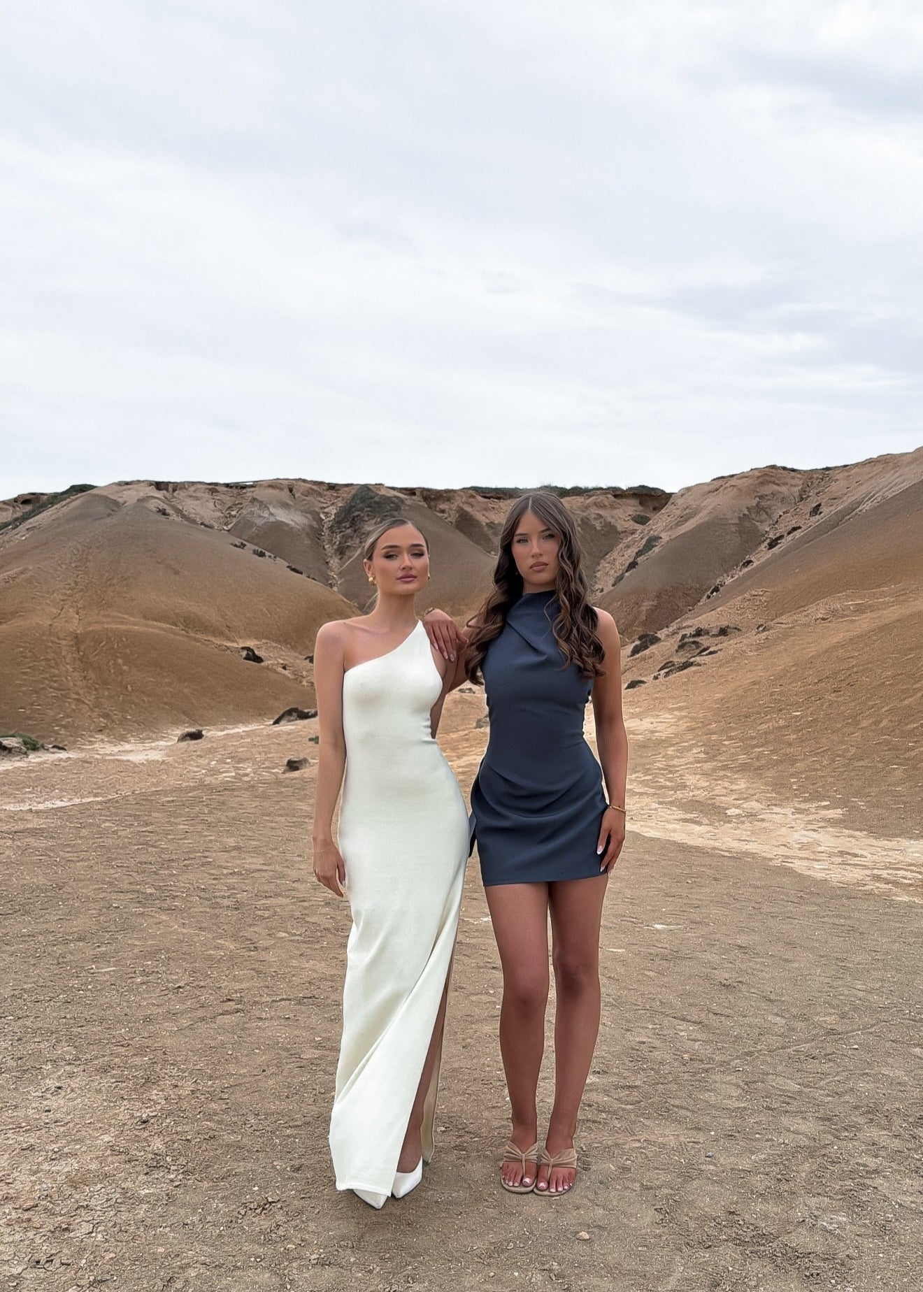 Two women in dresses standing in a desert landscape - maia the label dresses