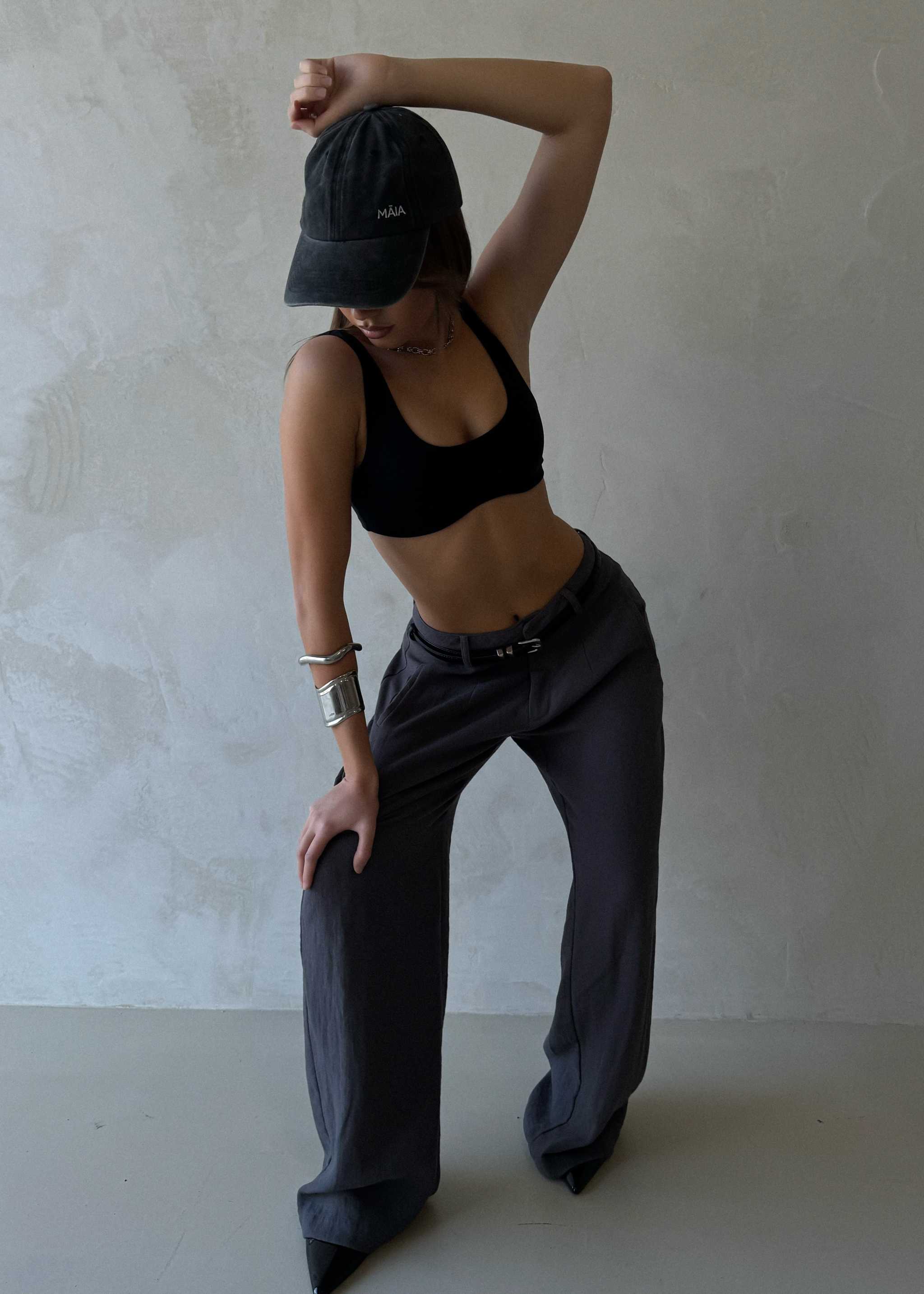 Arian Linen Pant Person wearing a black cap, sports bra, and gray pants against a plain background