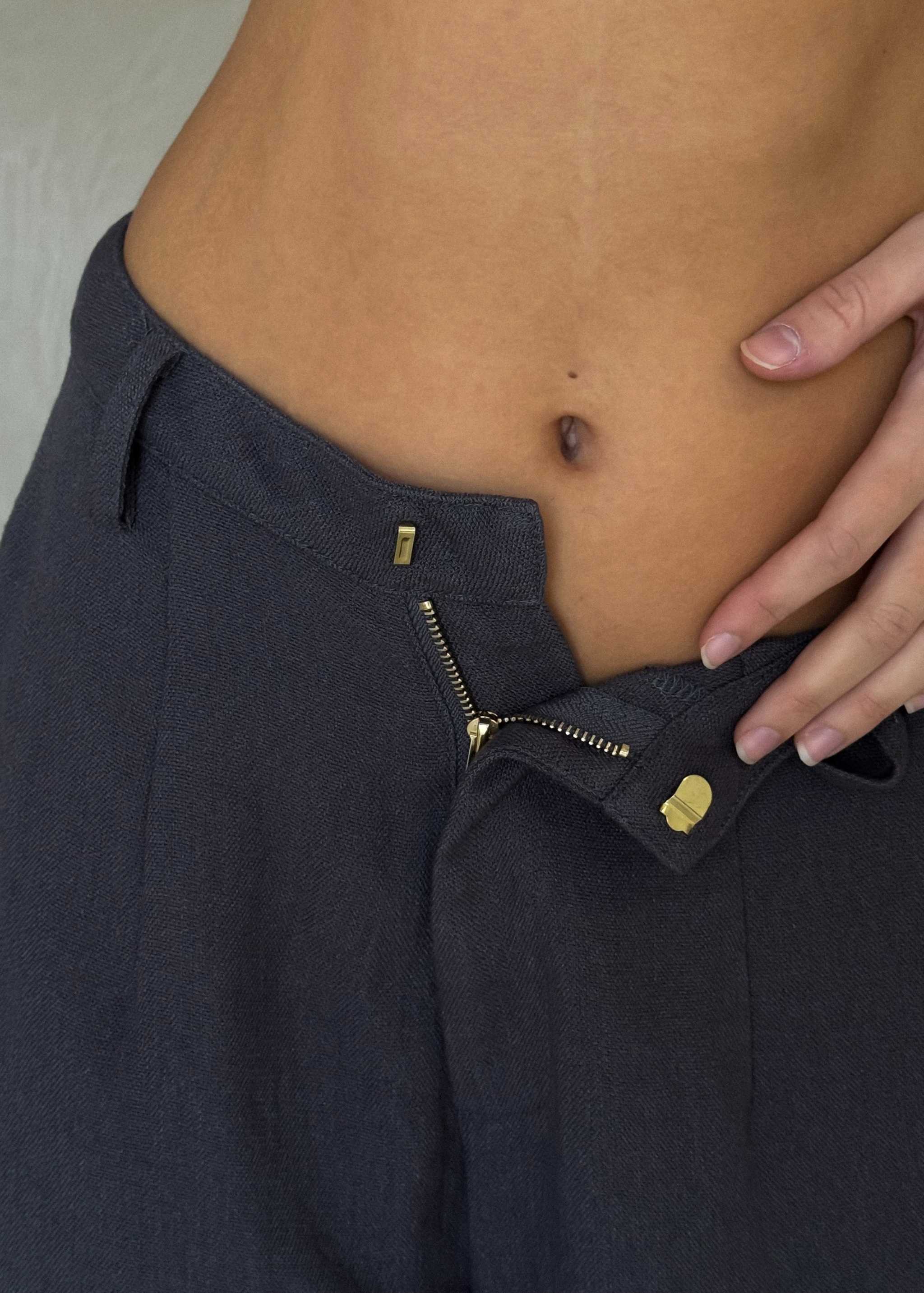 Arian Linen Pant Navy blue jacket with gold zipper and buttons on a neutral background